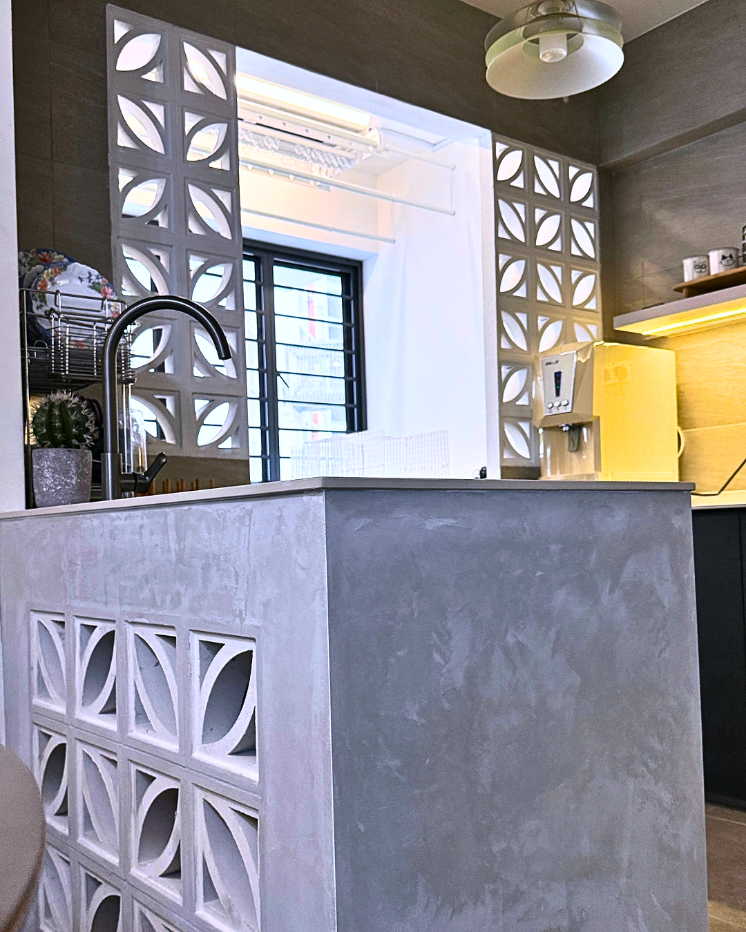 Concrete-finish kitchen island with breeze-block screening.