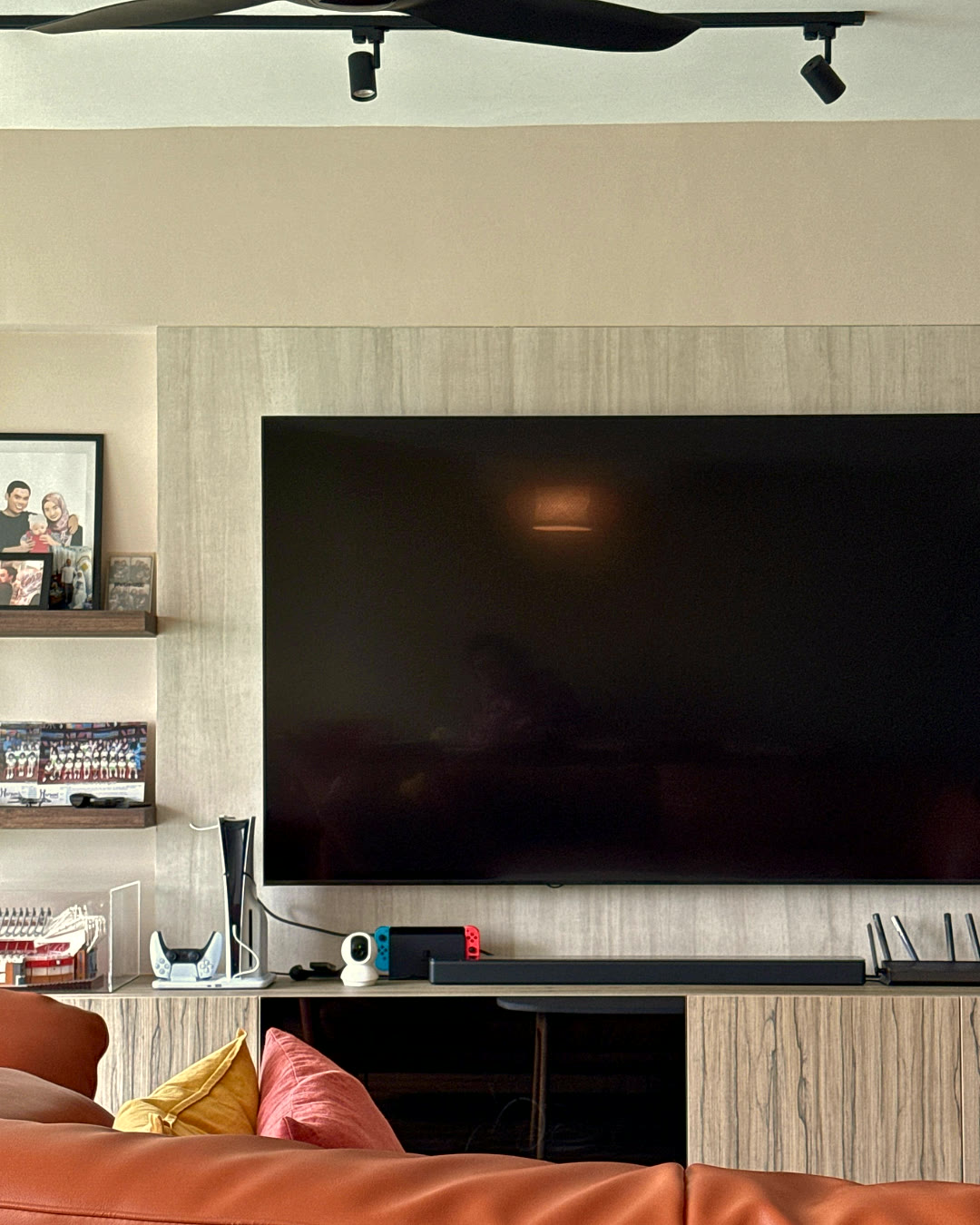 Living room with a wall-mounted television and warm-oak console.