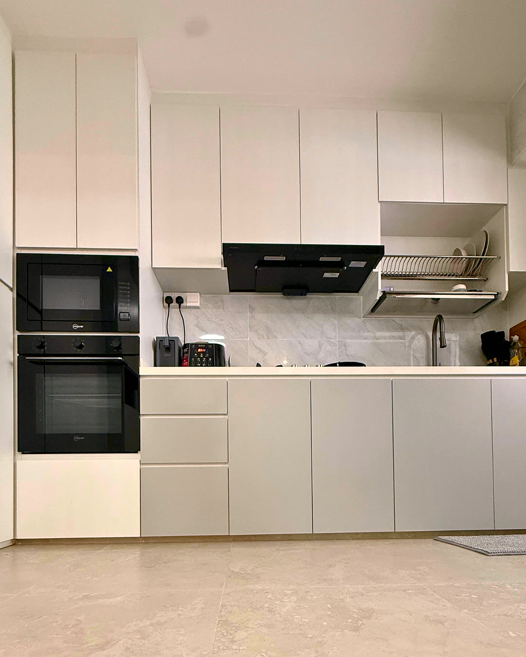 All-white galley kitchen with built-in double ovens.