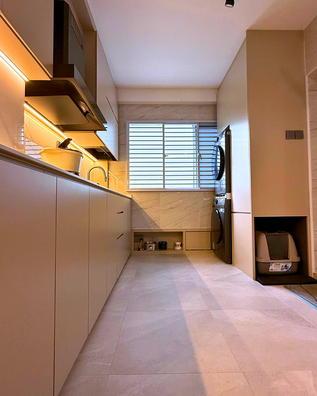 Long kitchen counter with track lighting and marble-look splashback.
